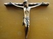 Bronskleurig kruisbeeld en religieuze afbeelding op hout.