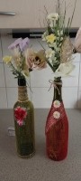 2 versierde flessen  met bloemen en lichtjes.
